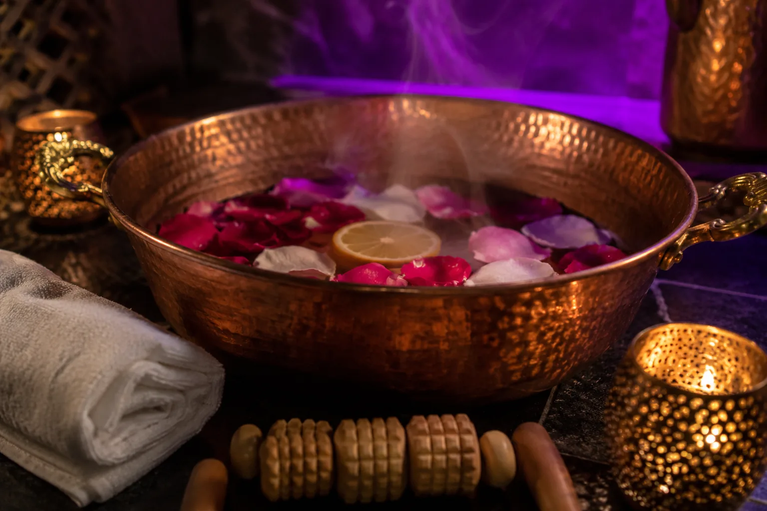 Ayak bakımı için bakır leğen, gül yaprakları ve tahta masaj rulosu · Lila Spa Bağcılar